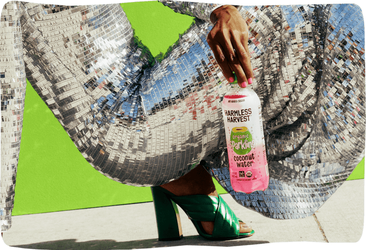 Hand holding Harmless Harvest Coconut water